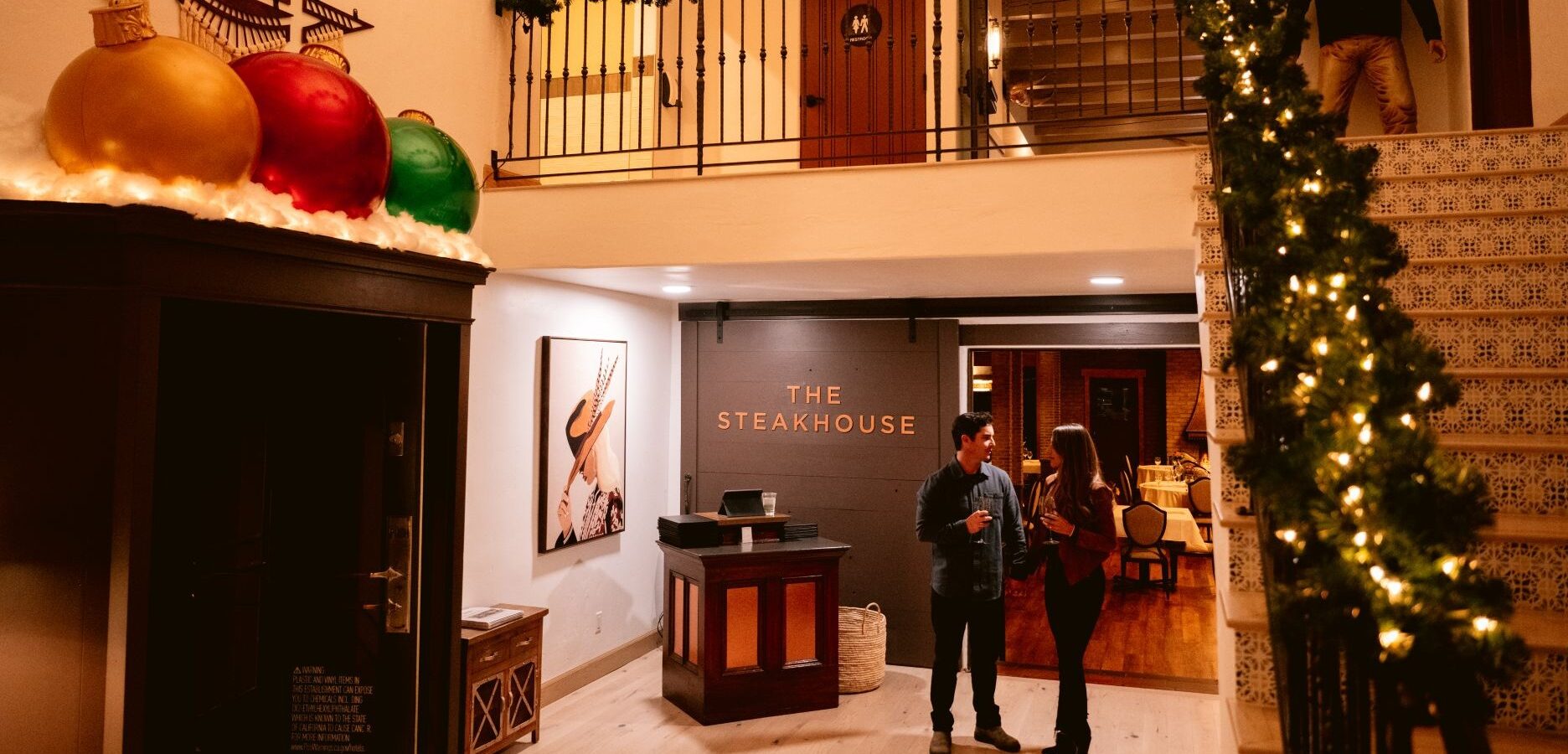 couple leaving Cattleman's Lounge in hotel lobby with holiday decorations