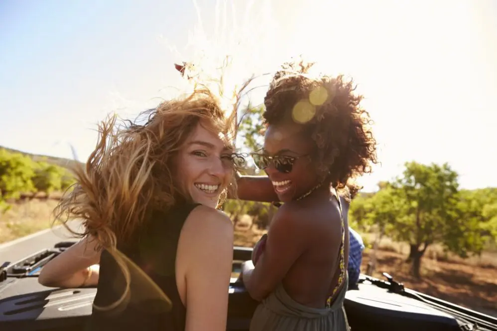 Two women in a car with windy hair